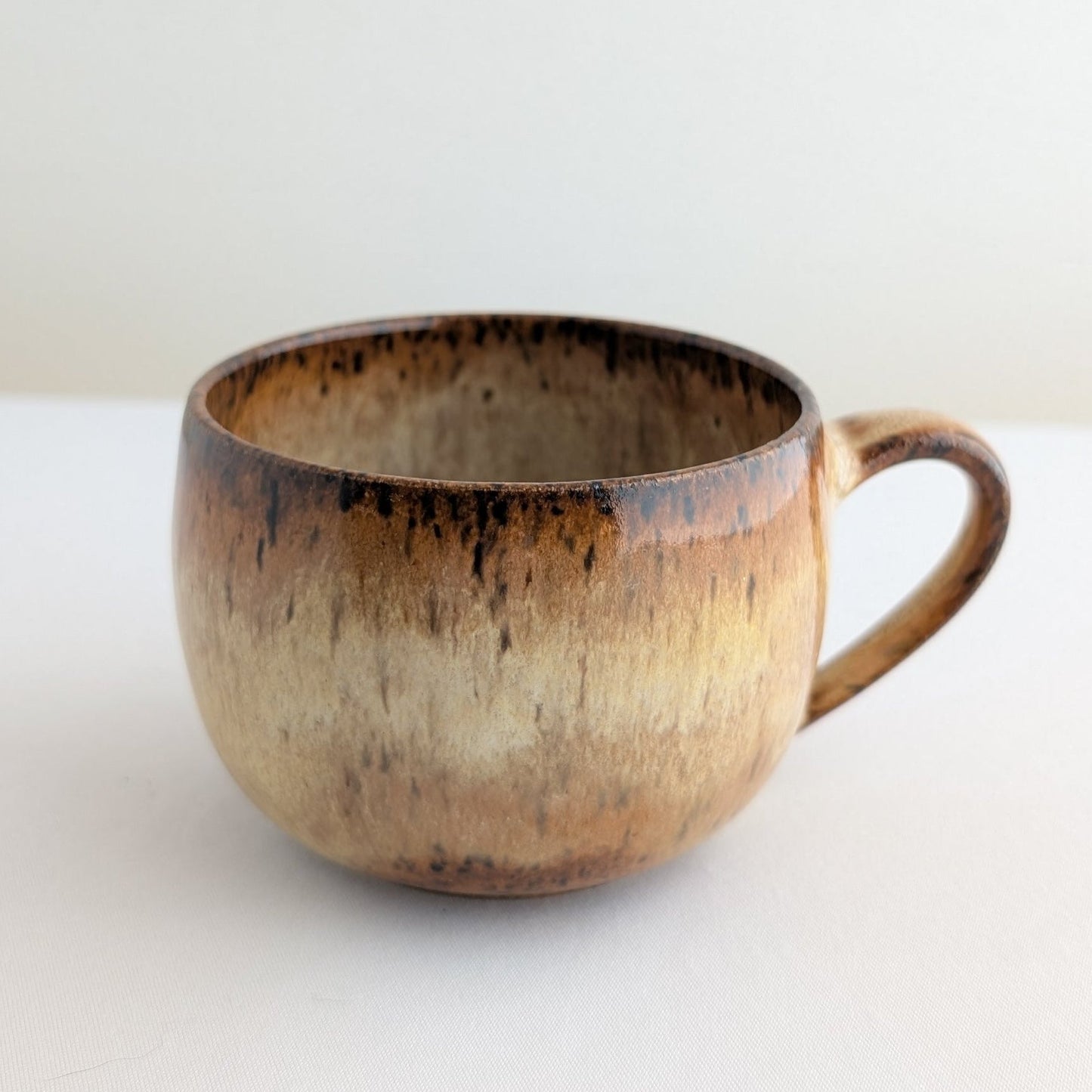 Ceramic mug with brown and beige gradient on a white background