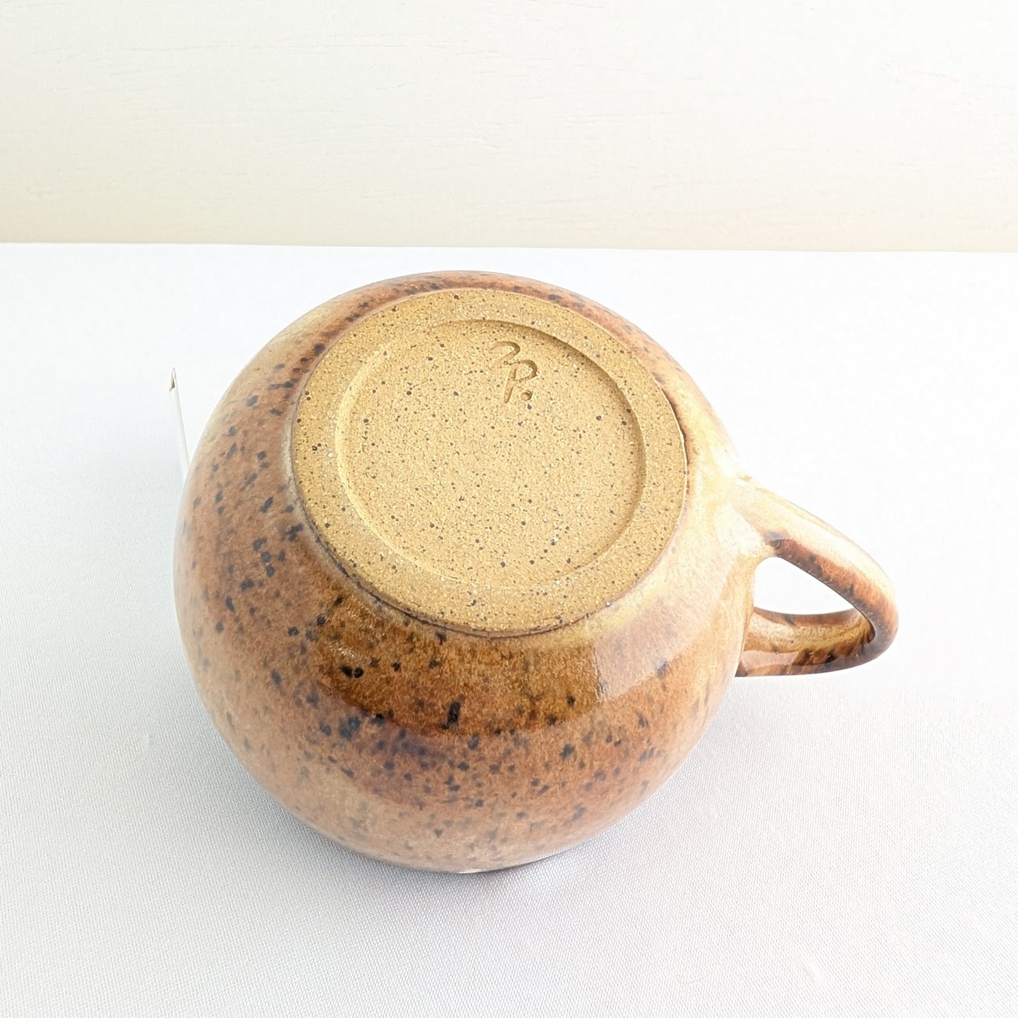 Ceramic mug with speckled brown design on a white background